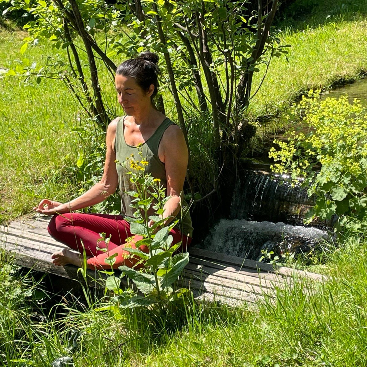 Christine Hector meditiert an einem Bach